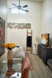 阿森斯UGA Penthouse Downtown Athens Walk To Stadium的客厅配有桌子和吊扇