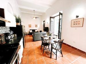 圣胡安65 Fortaleza 1 - N Colonial Apt W/ Balconies & Views的厨房以及带桌椅的起居室。