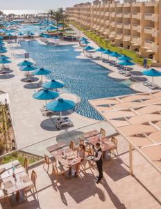 赫尔格达Amwaj Beach Club Abu Soma的享有带桌子和遮阳伞的游泳池的顶部景致