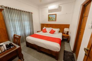 Fort KochiSeaCoast Inn FortKochi的酒店客房,配有一张带红色毯子的床