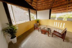 Fort KochiSeaCoast Inn FortKochi的客厅设有2张长椅和桌子