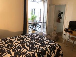 巴黎Chez Vero et Bruno的一间卧室配有一张床、一张书桌和一个窗户。