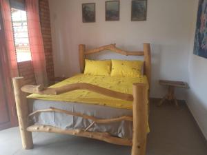 SêrroCasa dos Sonhos Hospedaria的一间卧室配有一张带黄色床单的木床