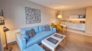 米兹多洛杰HOLIDAY HOME Bel Mare 308c的一间带蓝色沙发的客厅和一间厨房