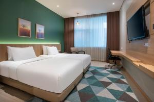 万隆Grand Tjokro Premiere Bandung的酒店客房设有一张大床和一张书桌。