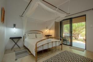 玛洛斯帕克ThornForest Luxury Bush Lodge的一间卧室配有一张带天蓬的床