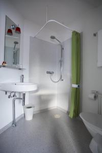 托尔斯港托斯翰酒店的带淋浴和盥洗盆的白色浴室