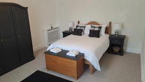 HalkirkRiverview Cottage的卧室配有一张带黑色枕头的大型白色床。