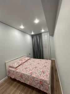 阿特劳Aportament in Abyroy Residence的一间卧室配有一张带彩色毯子的床