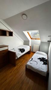 Vivienda Falda del Monsacro的阁楼卧室设有两张床,配有窗户