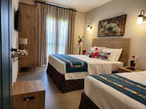 皮雷诺波利斯Flat da Mata - Resort Quinta Santa Bárbara的酒店客房设有两张床和窗户。