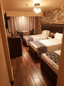 亚喀巴alnaher alkhaled boutiqu的酒店客房设有三张床和一张桌子