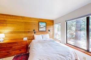 LakeshoreHuntington Lake Condo #38的一间卧室设有一张床和木墙