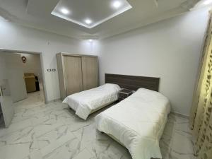 瓦迪穆萨Oskar Appartment的客房内设有两张床,铺有大理石地板。