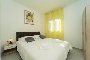 尼亚卢卡SVEMA APARTMAN的卧室配有白色的床和2条毛巾