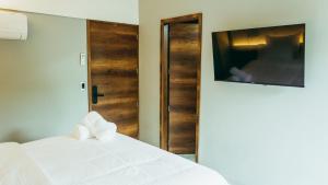 麦德林I Believe- All Suite Manila-Poblado的卧室配有白色的床和电视。