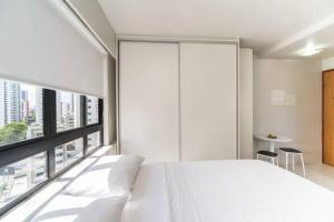 累西腓Classic Golden Point - Boa Viagem的卧室设有白色的床和大窗户