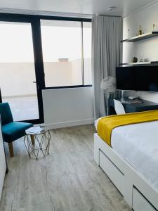 开普敦Modern Luxe Getaway for 2 with Stunning Cape Town Views, Fast WiFi, Queen Bed, Voice Control, Chic & Stylish Comfort的配有一张床和一把椅子的酒店客房