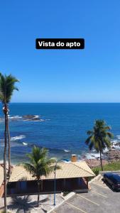 萨尔瓦多Ondina Apart Hotel - Apto 419的棕榈树停车场享有海景。