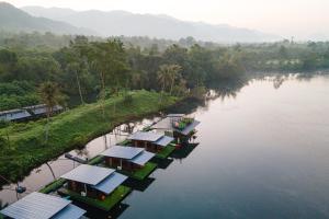 Tha KradanPhu Naphat Resort的享有河流的空中景色,拥有许多房屋