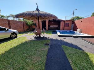 LuqueHospedaje Confortable en Luque的一座带遮阳伞和游泳池的房子