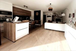 佩萨克Appartement 2 chambres centre的厨房铺有木地板,配有白色橱柜。