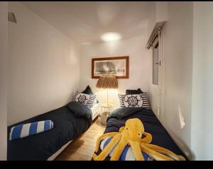 锡富尔勒普拉日Le rayon vert的一间卧室配有两张床,上面有章鱼