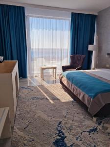 奥林普Meduza Hotel的卧室配有床、椅子和窗户。