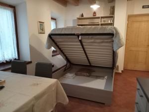莱维科特尔梅Casa Weber Levico Terme的配有一张桌子、一张桌子和一张桌子的床的房间