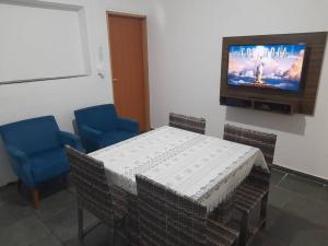 伊图Casa com 3 quartos的一间配备有桌子和两把椅子及一台电视的房间