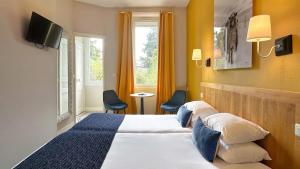 南特Hôtel Coeur De Loire的酒店客房设有床和窗户。