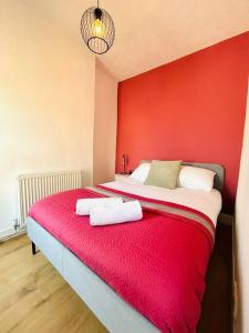 伦敦Elegant House in Stratford的红色的房间,床上配有两条毛巾