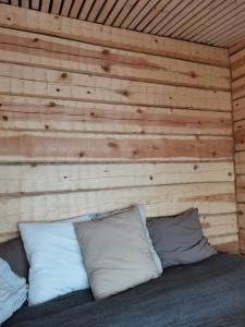 罗瓦涅米Wilderness Cabin Onnela的一间卧室配有木墙和床上的枕头
