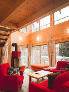 卡普伦The Kaprun Edition - Luxury Chalets & Style Suites的客厅配有红色家具和壁炉