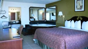 泰勒Royal Inn & Suites的酒店客房设有一张大床和一间浴室。
