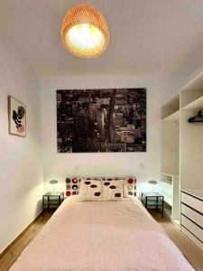 马德里centro Madrid / chueca (1)的卧室配有一张大床,墙上挂有绘画作品
