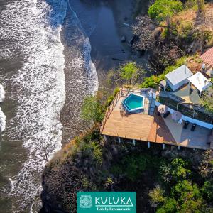 圣米格尔Kuluka Resort And Spa的水边悬崖上房屋的空中景观
