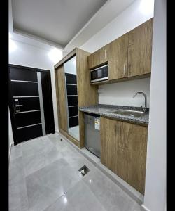 伊尔比德رويال جروب للشقق الفندقية的空厨房,配有木制橱柜和水槽