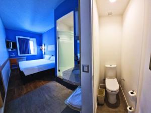 伊基克ibis budget Iquique的蓝色的客房设有1间带1张床和1间卫生间的浴室