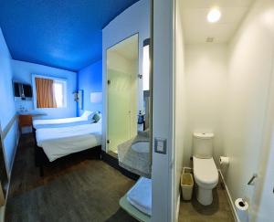 伊基克ibis budget Iquique的蓝色的客房设有床和浴室。