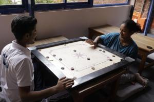 瓦拉纳西Live Free Hostel Varanasi的玩棋盘游戏的男人和女人