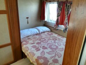 乌格连Room in Cabin - Caravan near the sea 1的一个小房间的小床,设有窗户