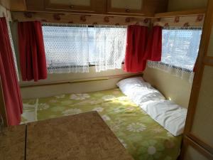 乌格连Room in Cabin - Caravan near the sea 1的一个小房间,窗户前设有一张床