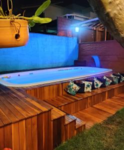 贝洛奥里藏特Hostel Trem Di Durmi的木制甲板上配有枕头的大型按摩浴缸