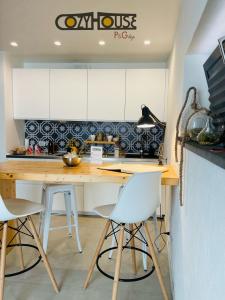 恩纳Cozy House的厨房配有木制柜台和白色橱柜。