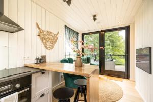 米尔洛Onder het dak van Brabant的厨房配有桌子和一些绿色椅子