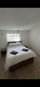 利物浦Entire 3 bedrooom holiday home的一间卧室配有一张带白色床单的床和一扇窗户。