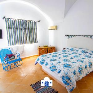 哈马马特Maison eirene的一间卧室配有一张床和一张蓝色椅子