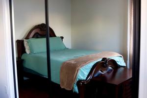  东港Cozy East Haven Apartment - Walk to Beach!的一间卧室配有一张带镜子的绿色床