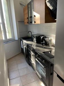 卡代纳Studio hypercentre Cadenet的厨房配有水槽和炉灶 顶部烤箱